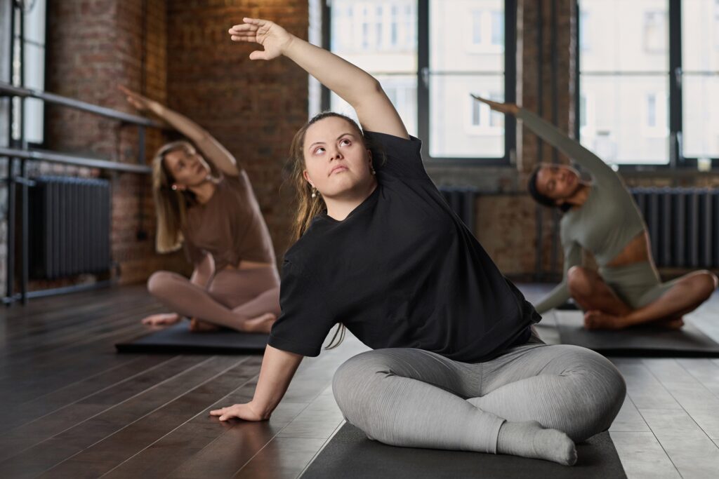 A girl with down syndrome doing yoga with other women